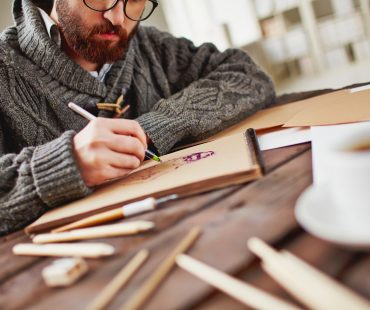 Artist at work Image of young bearded man drawing
